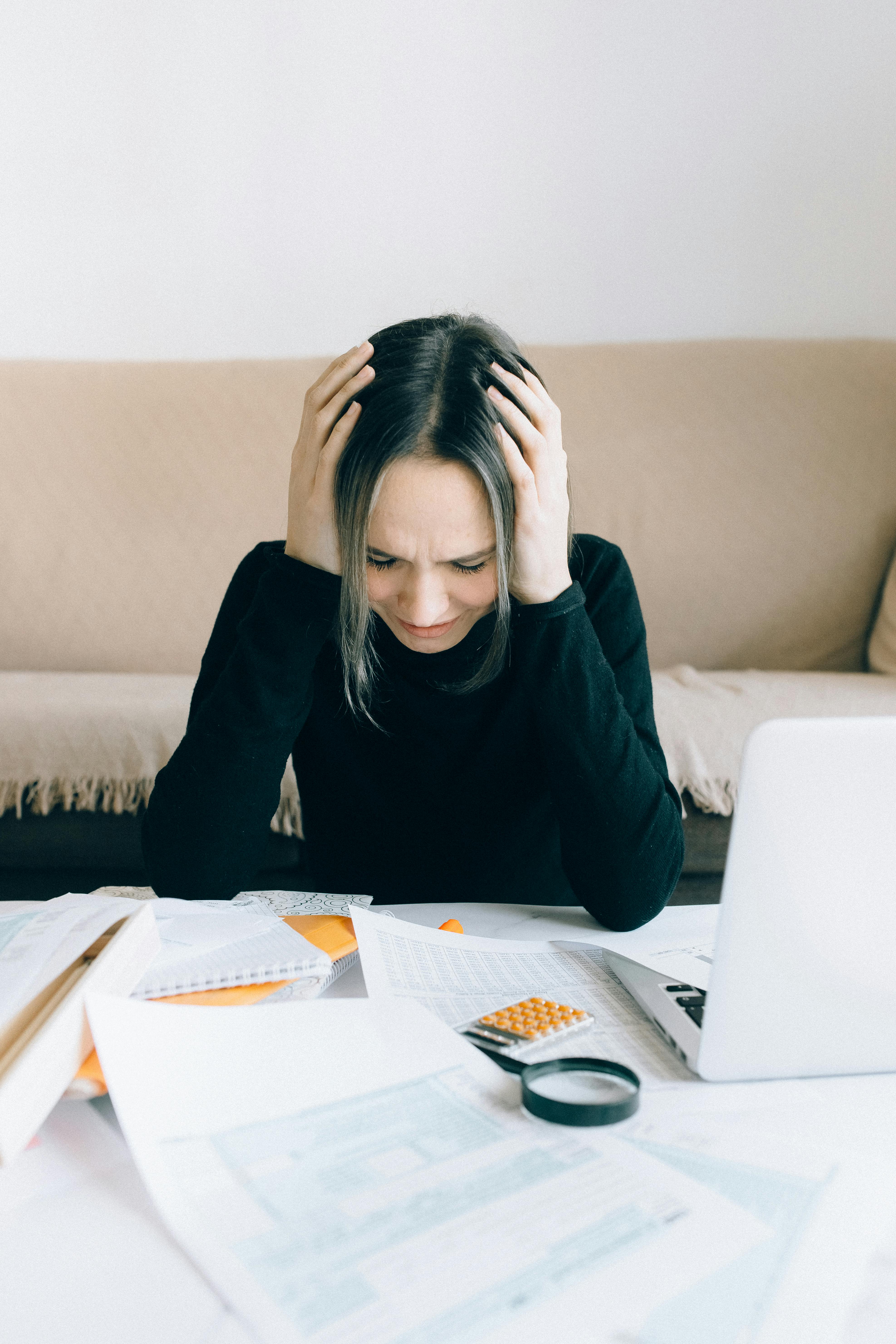 A frustrated freelancer overwhelmed by piles of paperwork.